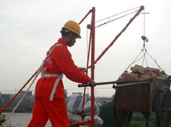 工人利用小型吊運(yùn)機(jī)高空吊物時(shí)也要系好安全繩